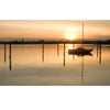 Martha’s Vineyard Wide by Schiffer Publishing, Ltd. captures a sailboat floating at sunset near Martha’s Vineyard, surrounded by wooden posts, with orange and yellow skies reflecting on calm waters and silhouettes of trees and buildings on the horizon.