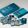 The AboraMana card set by Schiffer Publishing, Ltd. is shown with an open guidebook and vibrant self-discovery cards arranged in front of the box, featuring mystical goddess-themed artwork.