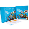 A blue box and "The Future Architect's Tool Kit" by Schiffer Publishing, Ltd. are displayed upright, with a white eraser and notepad featuring faint blue grid lines in front, ready for aspiring architects beginning their design journey.