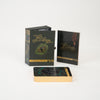 The Wild Elemental Oracle by Schiffer Publishing, Ltd. is a boxed set featuring animal oracle cards with gold edges and vibrant designs, plus a guidebook—all artfully displayed on a white background.