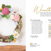 Modern Crochet Garden by Schiffer Publishing, Ltd. is displayed on a wall, featuring handmade pink, cream, and green crocheted flowers, leaves, and succulents. Instructions and materials for making the wreath appear to the right.