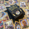 The Secret Woods deck by Schiffer Publishing, Ltd. features illustrated intuition cards with whimsical forest creatures and includes a black and gold guidebook, all displayed on a dark surface.