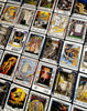 A spread of The William Blake Tarot of the Creative Imagination by Schiffer Publishing, Ltd. displays vivid cards with unique artwork and symbols, inspiring creativity against a dark backdrop.