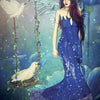 A fantasy illustration of a serene angel with long red hair and blue wings, in a flowing blue gown by a dove-held swing, evokes healing and peace—perfect for the Angels of Healing and Hope Oracle by Schiffer Publishing, Ltd.