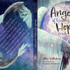 The Angels of Healing and Hope Oracle from Schiffer Publishing, Ltd. features a cover with angel wings, a starry sky, and glowing light. Illustrated by Yasmeen Westwood, the poetic back text invites readers to connect with angels through oracle cards.
