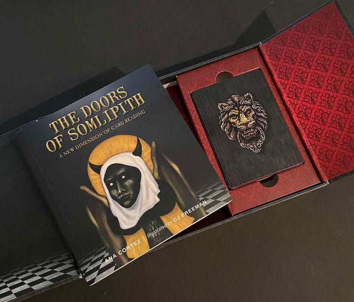 The Doors of Somlipith by Schiffer Publishing, Ltd. is an esoteric card reading set with a book and a deck featuring a gold-embossed lion face, all displayed in a decorative red and black box.