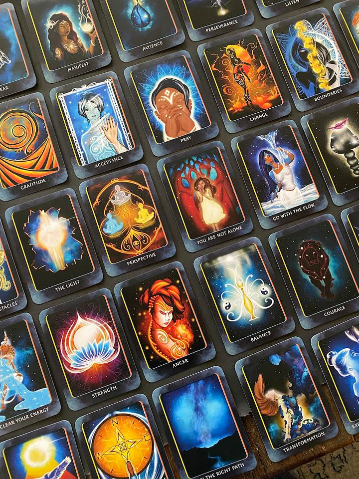 A spread of colorful Higher Self Oracle cards by Schiffer Publishing, Ltd., featuring mystical art and guidance words like “Acceptance,” “Strength,” “Anger,” “Patience,” and “Transformation.”.