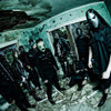 Nine people in black outfits and horror masks pose in a decaying, debris-strewn room—an image worthy of "The Art of Metal" by Schiffer Publishing, Ltd., evoking the chilling vibe of iconic heavy metal cover art.