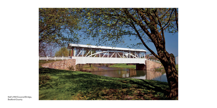 A white wooden covered bridge with a stone base crosses a calm creek amid greenery under a blue sky. Text reads, "Pennsylvania's Covered Bridges—Schiffer Publishing, Ltd." celebrating historic bridges of the region.