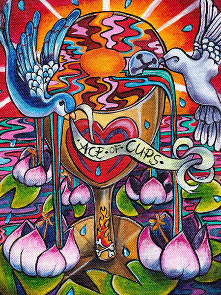 Vivid, hand-painted Ace of Cups from the Bonefire Tarot by Schiffer Publishing, Ltd., featuring a golden heart chalice, two birds pouring water, lotus flowers below, and radiant rays inspired by classic Sailor Jerry tattoo flash.