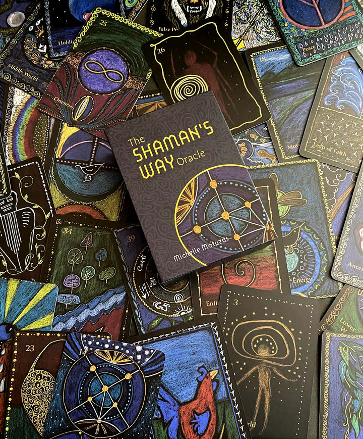 A deck of vibrant ascension cards with mystical hand-drawn art is displayed, featuring The Shaman’s Way Oracle by Schiffer Publishing, Ltd. at the center—an ideal tool for spiritual healing.