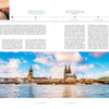A panoramic view of Cologne, Germany, features the Cologne Cathedral, Hohenzollern Bridge, and vibrant riverside buildings—a scene celebrated in Schiffer Publishing, Ltd.'s River Cruises—where boats glide under sunny skies along the Rhine.
