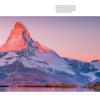The Wild Alps from Schiffer Publishing, Ltd. captures the snow-capped Matterhorn glowing pink at sunrise, reflected in a calm alpine lake—showcasing clear skies, soft hues, and the dramatic landscapes of the Valais Alps.