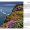 A scenic magazine spread from "The Wild Atlantic" by Schiffer Publishing, Ltd. features dramatic western European sea cliffs, rocky shores, and a lighthouse on a grassy headland with wildflowers under moody sunrise and sunset skies in Mainland, Scotland.