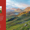 A scenic UK landscape with green hills, cliffs, and a lake under a blue sky. On the left, a red panel displays info about At Home with Royalty by Schiffer Publishing, Ltd., with a photo of an ornate historic building.