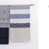 Two textiles hang side by side on a rod—one shows counted sashiko embroidery in black and white, the other displays Kogin designs in beige, blue, and white. Text on the right reads “Two Kinds of Embroidery.” Product: Counted Sashiko Embroidery by Schiffer Publishing, Ltd.