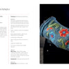 A person wearing Nordic Hands gloves by Schiffer Publishing, Ltd., featuring a flower design inspired by Scandinavian fiber art.