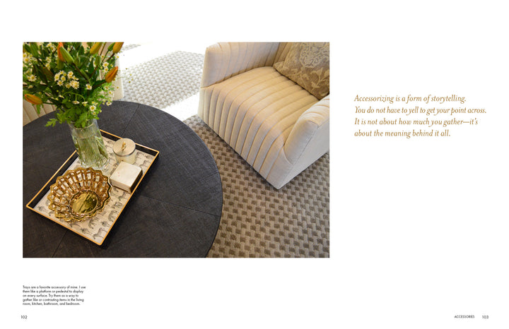 A cozy, striped armchair sits by a round dark coffee table topped with a tray of flowers, a book, and gold accents. On the right, a quote from Schiffer Publishing, Ltd.'s "It's All in the Mix" highlights the art of accessorizing.