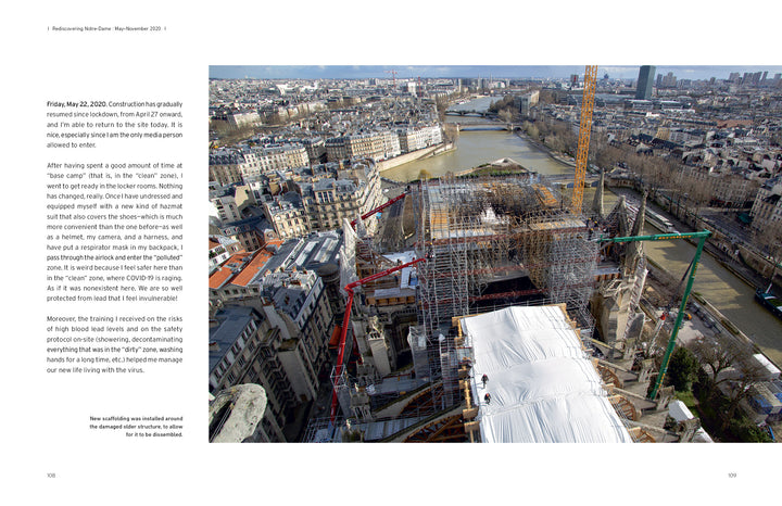 Captured in "Restoring Notre-Dame de Paris" by Schiffer Publishing, Ltd., a wide view shows Notre-Dame Cathedral under restoration after the fire, surrounded by scaffolding, cranes, the Seine River, and Parisian buildings on a clear day.
