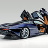 A sleek McLaren by Schiffer Publishing, Ltd. sits on a white background with driver-side scissor doors open, showing a tan and black interior, aerodynamic lines, and large alloy wheels.