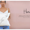 A woman in a white tank top holds the "Stitch with One Line" pillow by Schiffer Publishing, Ltd., featuring minimalist hand and butterfly embroidery—an inspiring project for beginners—against a pale pink background labeled "Home.