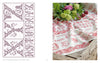 On the left, a grid displays French monogram cross-stitch patterns from "Vintage French Needlework" by Schiffer Publishing, Ltd.; on the right, an embroidered cloth with red lettering and floral motifs sits next to fresh flowers.