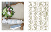 The Vintage French Needlework by Schiffer Publishing, Ltd. features an armchair with floral accents and a pillow adorned with ornate A and S monograms, beside a chart displaying decorative alphabet embroidery patterns from A–Z.