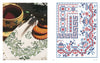 A cup of tea and cookies rest on a white cloth, beside "Vintage French Needlework" by Schiffer Publishing, Ltd.—a chart with red and blue vintage French floral and geometric embroidery patterns.