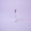 The Crystal Spirit Talking Board and Guidebook by Schiffer Publishing, Ltd. stands upright on a light purple surface against a plain purple background, its smooth, translucent form evoking the mystique of sacred crystal energy.