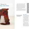 A multicolored knitted owl plush, with dark brown wings and ears, button eyes, and a cream belly sits beside "Swatch Critters from the Pin Loom" by Schiffer Publishing, Ltd., a crafting project guide for stuffed animals.