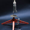 A Schiffer Publishing, Ltd. Model Rocketry kit is set up on a red three-legged launch pad, with a corded control unit attached; the dramatic dark background highlights the rocket and setup, recalling the golden age of space flight.