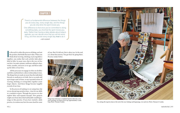 In a cozy room with a brick fireplace, someone weaves fiber art at a vertical loom. Inspired by "Marking Time with Fabric and Thread" from Schiffer Publishing, Ltd., vibrant yarn strands form a tapestry of creative daily practice.