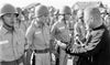A man in dark clothing inspects young soldiers standing at attention outdoors with tents behind them—a scene from The Fighting Fathers by Schiffer Publishing, Ltd.