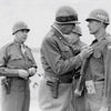 A U.S. Army general pins a medal on a soldier of the 39th Infantry Regiment during a WWII ceremony in the field—scene from "Dying Hard" by Schiffer Publishing, Ltd.