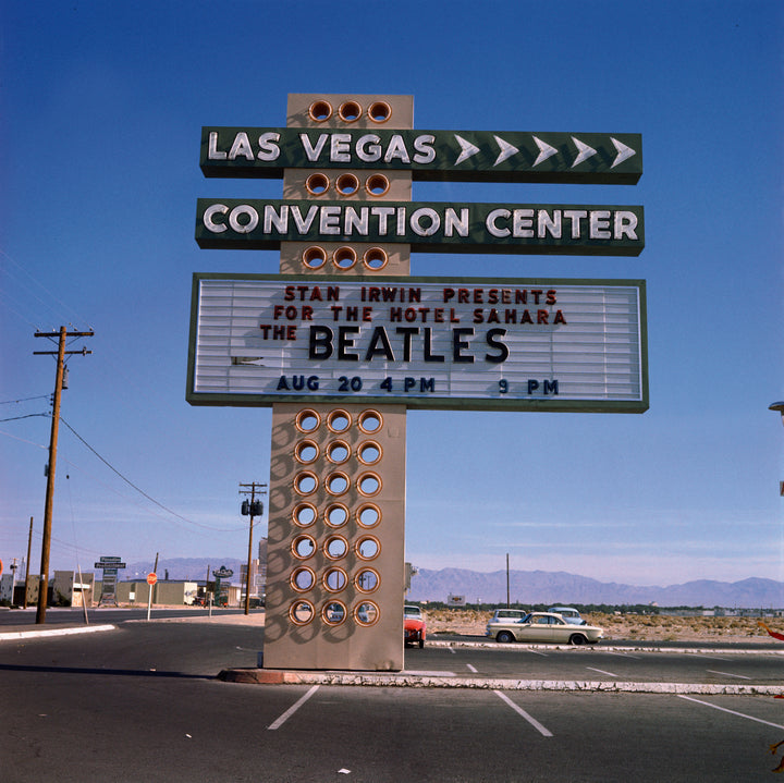 The Beatles in America by Schiffer Publishing, Ltd. features a vintage sign at the Las Vegas Convention Center for a Beatles concert on August 20 at 9 PM, with an almost empty parking lot and mountains visible in the background.