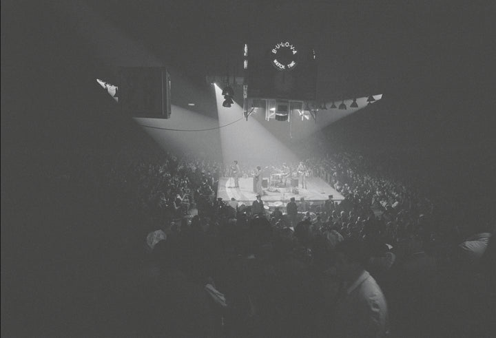 The Beatles in America" from Schiffer Publishing, Ltd. features a black-and-white photo of Beatlemania: a packed indoor arena, the band on a lit center stage, surrounded by fans and overlooked by a large scoreboard.