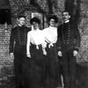 Four people pose outside a brick building: two men in military-style uniforms and two women in skirts and blouses. The black and white image evokes US Navy history, echoing the spirit of "King's Navy" by Schiffer Publishing, Ltd.