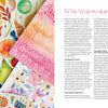 A flat lay displays vibrant fruit, flower, and holiday ornament watercolor paintings beside Modern Watercolor Workshop by Schiffer Publishing, Ltd., featuring beginner-friendly projects and step-by-step painting tips.