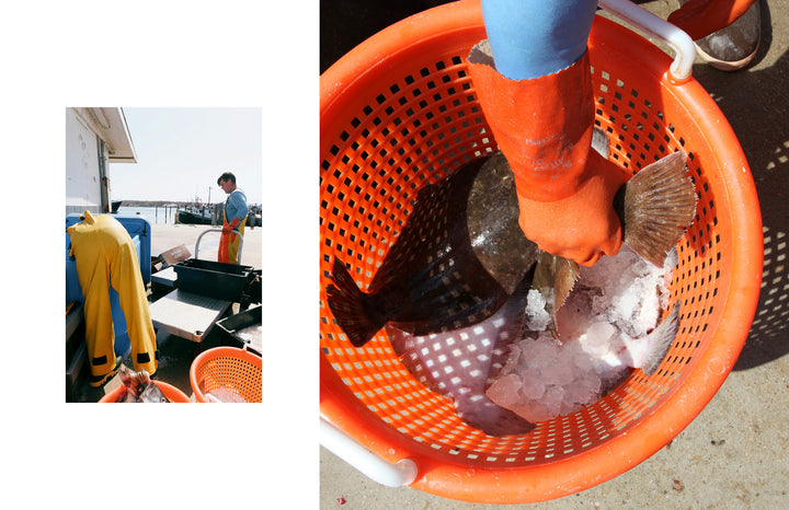 Someone wearing orange gloves holds a large flat fish in an ice-filled orange basket, while another in yellow overalls stands by fishing gear at the South Fork Long Island waterfront. From Out East from Above by Schiffer Publishing, Ltd.