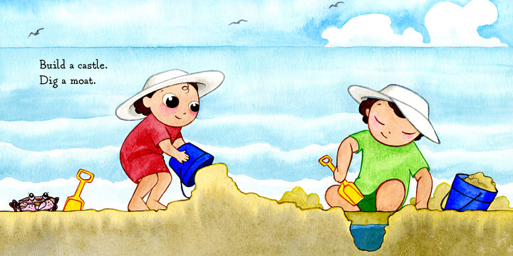 Two children in white sun hats build a sandcastle with buckets and shovels on a beach, with the ocean, sky, a crab, and shells nearby. "Hello, Beach!" by Schiffer Publishing, Ltd. invites little ones to build a castle and dig a moat.