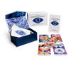 The Unifying Consciousness Tarot by Schiffer Publishing, Ltd. is shown with an open box featuring a rose and eye design, a guidebook, and colorful Rider-Waite-Smith-inspired cards spread out.