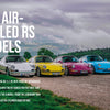 A lineup of vibrant Porsche RS cars, featured by Schiffer Publishing, Ltd., including a standout Renn Sport model, parked on a gravel road.