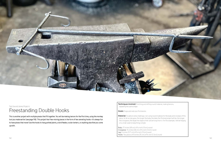 A metal double hook sits on an anvil amid blacksmithing tools, ideal for learning with Schiffer Publishing, Ltd.'s "Contemporary Blacksmithing for Beginners"—great for projects like freestanding double hooks.
