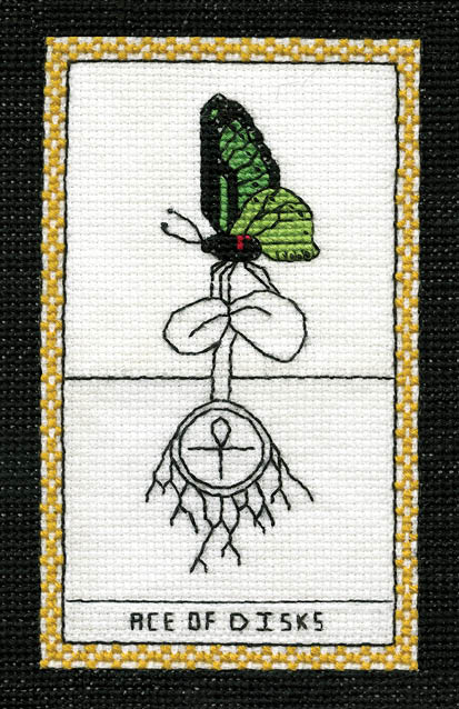 A cross-stitched tarot card from The Butterfly Wisdom Tarot by Schiffer Publishing, Ltd. features a green butterfly on leaves above roots circling an ankh, gold-bordered, and labeled ACE OF DISKS at the bottom.
