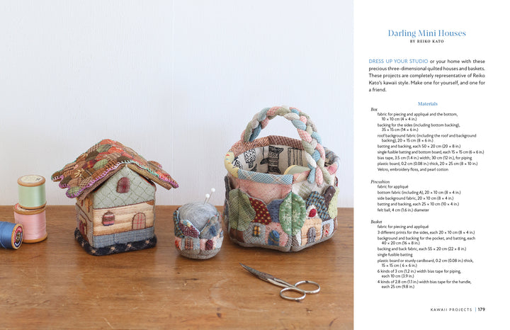 Three quilted miniatures—a house, a handled basket, and a pincushion—rest on a wooden table with scissors and thread. Find instructions for these charming projects in Kawaii Appliqué Quilts from Japan by Schiffer Publishing, Ltd.