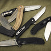 Five Schiffer Publishing, Ltd. Folding Knives with varied handle designs and finishes are arranged in a fan-like display, partially overlapping on a green fabric background.
