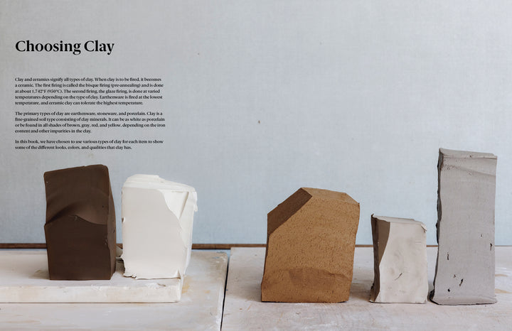 Five clay blocks in brown, white, tan, and gray are arranged on wood—ideal for beginners using Practical Pottery by Schiffer Publishing, Ltd. to select the best clay for ceramics projects.