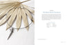 The book "Projects and Techniques for Metal Clay Jewelry" by Schiffer Publishing, Ltd. is shown on a beige palm leaf alongside instructions and materials, its cover featuring an elegant metal choker with a spiral shell pendant.