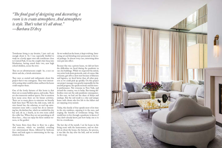 A modern, elegant living room inspired by Penny Drue Baird, featuring elements from "PowerHouse" by Schiffer Publishing, Ltd.: a light palette, curved sofa, gold-accented glass table, large windows, mirrored panels, and a contemporary fireplace.