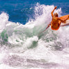 A surfer in an orange swimsuit rides a yellow board on vibrant blue waves. Discover uncharted surf spots with surfEXPLORE from Schiffer Publishing, Ltd.—the ultimate guide for adventurous surfers seeking new destinations.